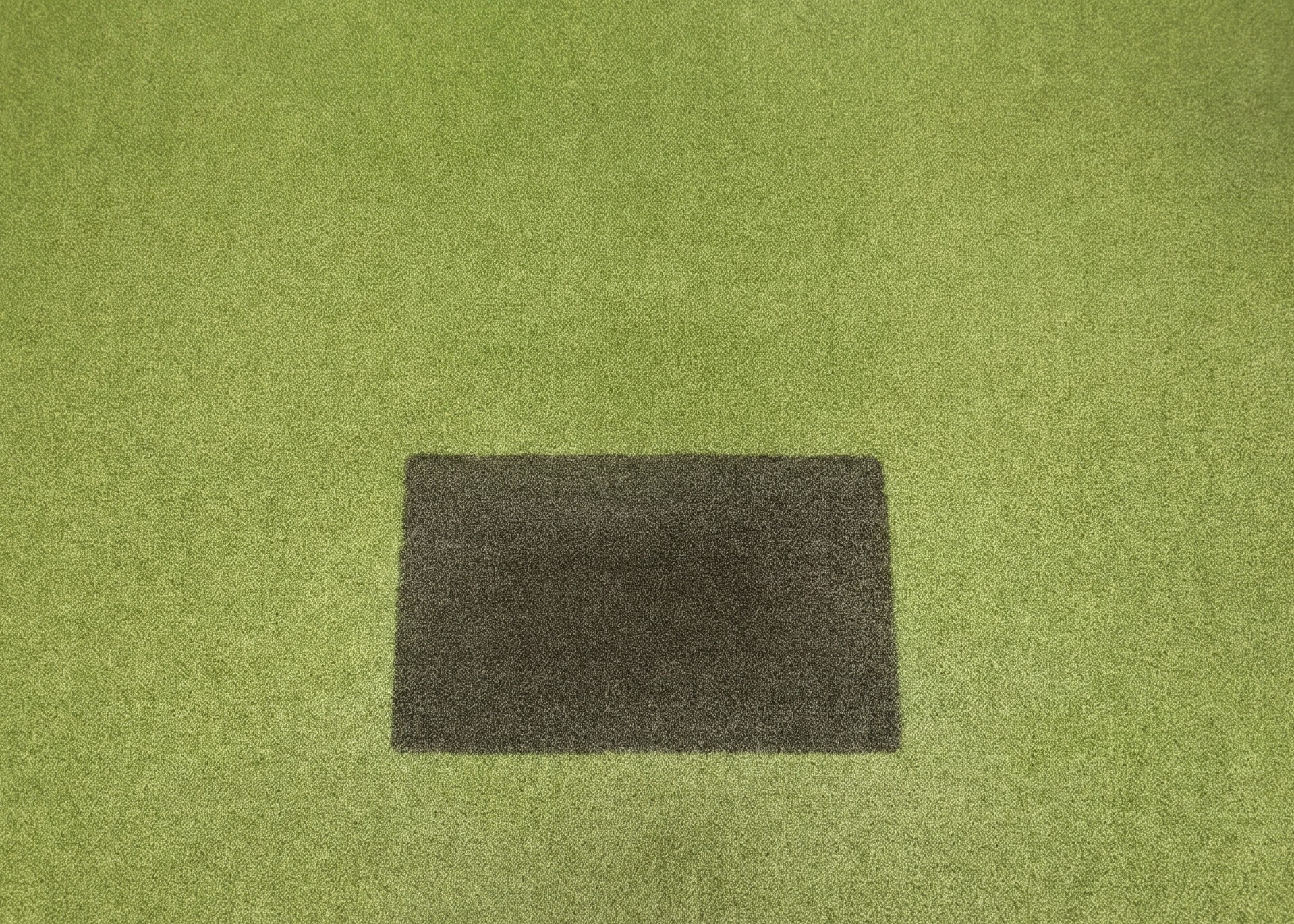 Golf simulator turf with a dark hitting strip, seen from the player's address position